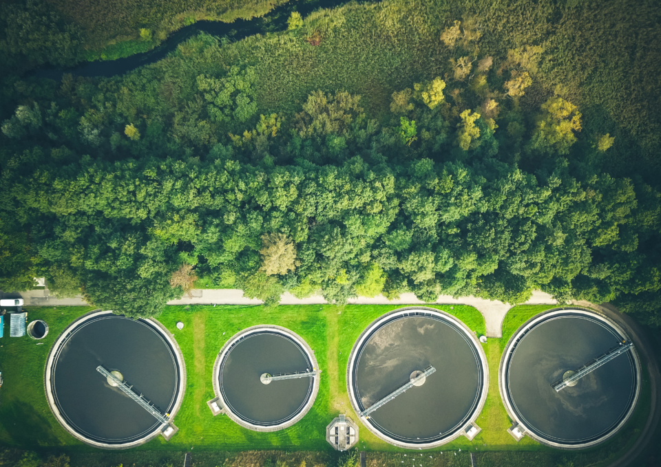 Aerial shot of sewage treatment plant placed near a river, Denmark. Aerial view shot with drone.